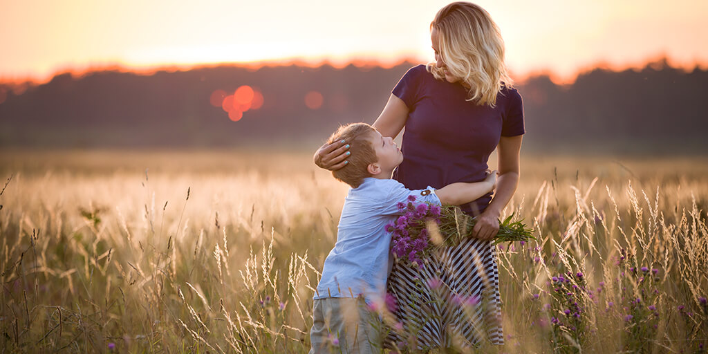 Header Image. Cute boy hugging mother.