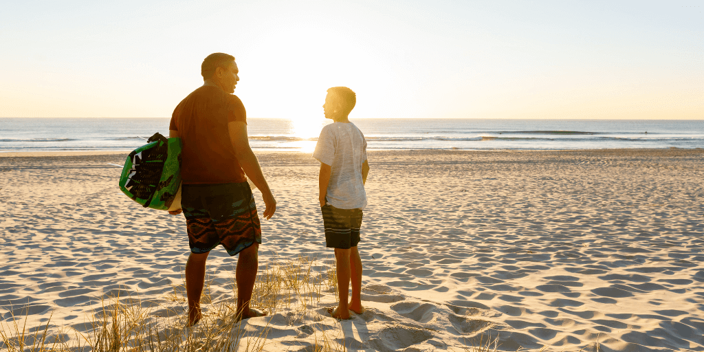 carer and child at the beach talking