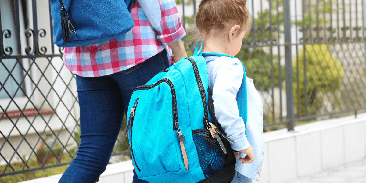 young girl walking to school with carer transitioning