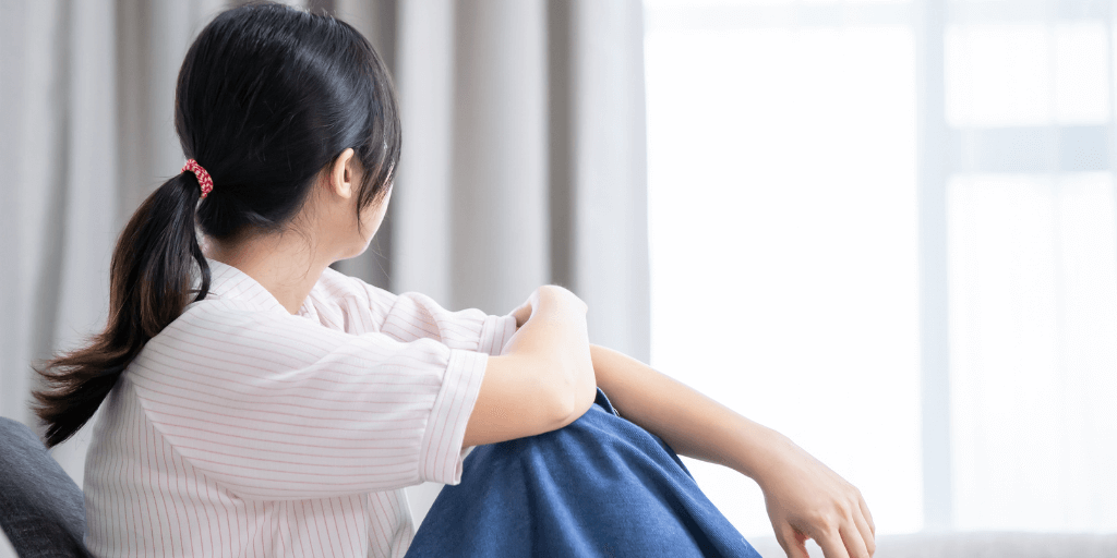 girl thinking while looking out window about change