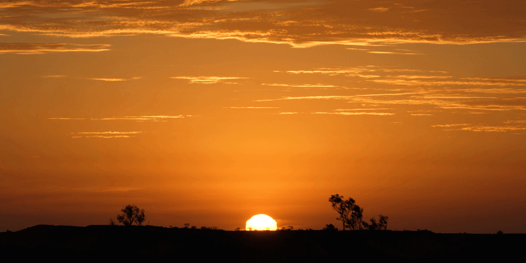 A view of the horizon with the sun setting upon it.