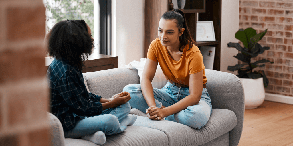 Two teenage girls sitting on couch