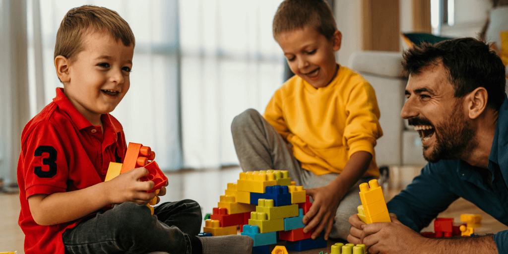A dad and his sons playing with Lego blocks
