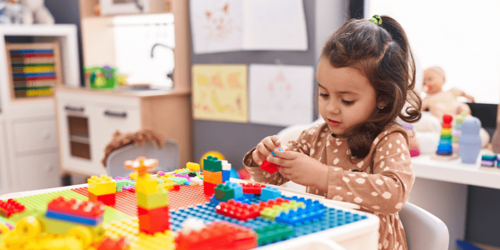 A young girl in a kindergarten setting practising child-centred play with blocks