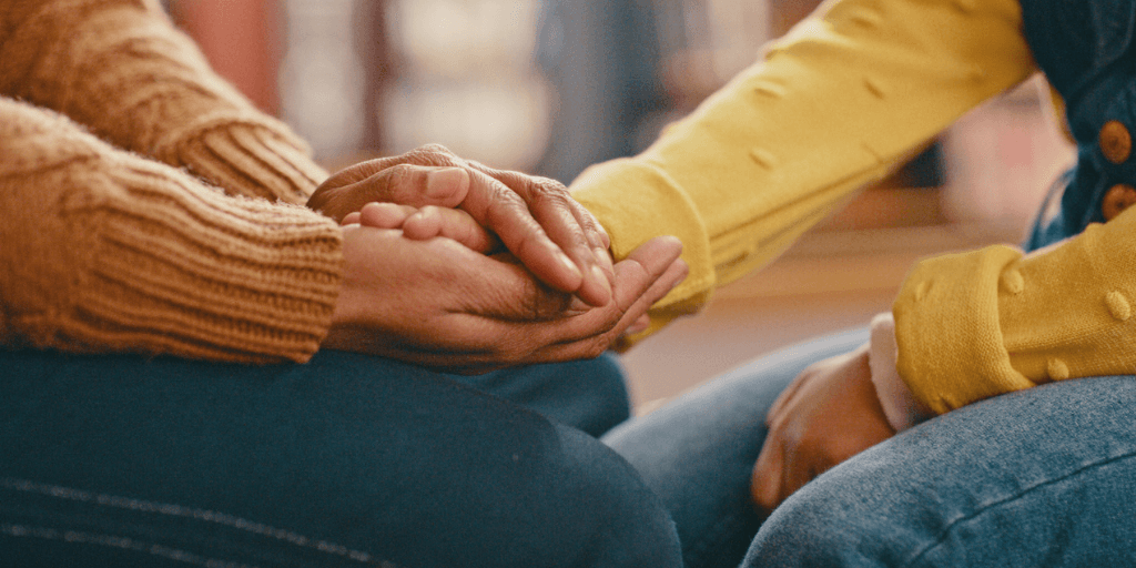 Parent and child holding hands in therapy session to address fawning response